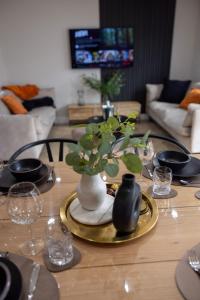 a dining room table with a vase with flowers on it at Charming 3-Bed House with 1 Parking space in Canterbury