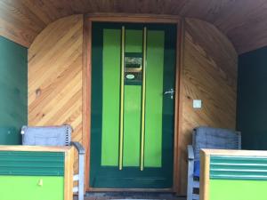 een groene deur in een kamer met 2 stoelen bij Ecostay de Wildernis in Wilp