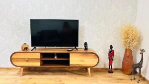 ein Fernseher auf einem hölzernen Unterhaltungsmöbel in der Unterkunft Cosy Home in Rustawi