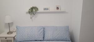 a blue pillow with a plant on a white wall at APARTAMENTOS IGLESIA DE SANTIAGo II in Jerez de la Frontera