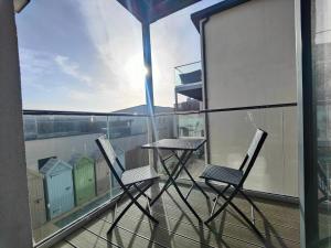 two chairs and a table on a balcony at 8 Putsborough - Luxury Apartment at Byron Woolacombe, only 4 minute walk to Woolacombe Beach! in Woolacombe