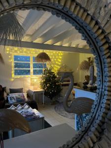 una sala de estar con un árbol de Navidad y un espejo en Gîte Le Chat Chez Qui J'habite, en Saint-Aubin-sur-Mer