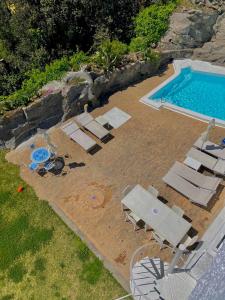 een uitzicht over een zwembad met ligstoelen en een zwembad bij Villa Marecoco in Ischia