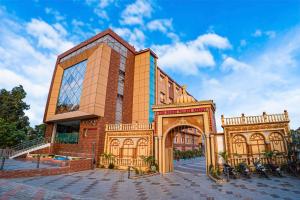 a large brick building with an arch in front at THE BODHI PALACE RESORT in Bodh Gaya