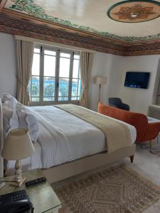 a bedroom with a large bed with a large window at La Menara Hotel & SPA in Sidi Bou Saïd