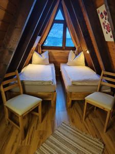 ヴァルトキルヒェンにあるFerienhaus mit Seeblickの窓付きの客室で、ベッド2台と椅子2脚が備わります。