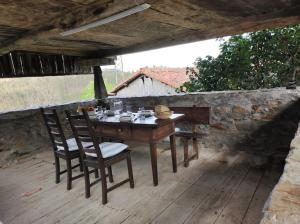 una mesa de madera y sillas en una terraza de madera en 10A04 Casa Petacos, en Pravia