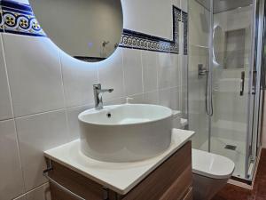 a white bathroom with a sink and a shower at 10A04 Casa Petacos in Pravia