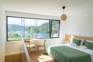 a bedroom with a bed and a large window at Costa D'Ouro in Castelo de Paiva