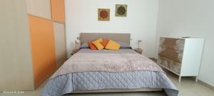 a bedroom with a bed with two orange pillows at Sweet holidays in Matera