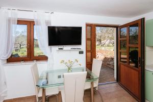 a dining room with a glass table and a television at Roko Opaćac in Zadar