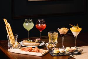 - une table avec des verres à vin, de la nourriture et des boissons dans l'établissement Atarayo Nishiizu Onsen, à Izu