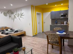 薩勒河畔哈雷的住宿－Piano Apartment Halle - Netflix - Free WiFi 4，厨房以及带桌子和沙发的客厅。