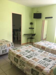a hotel room with two beds and a desk at Le Signoret in Sault-de-Vaucluse