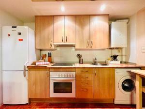 a kitchen with wooden cabinets and a white refrigerator at Apartamento Alberto in Margudgued +12 photos