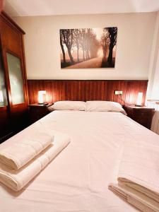 a large white bed in a bedroom with a picture on the wall at Apartamento Alberto in Margudgued