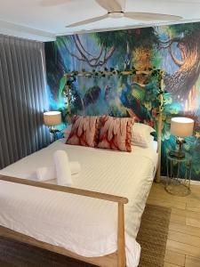 a bedroom with a bed with a painting on the wall at License To Chill • Couple’s Escape in Mooloolaba in Mooloolaba