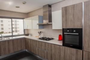 a kitchen with wooden cabinets and a stove top oven at Appartement Marina in Casablanca