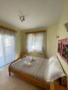 een slaapkamer met een bed met twee handdoeken erop bij Maisonette by the sea in Keramotí