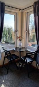 1 mesa y 2 sillas en una habitación con ventana en Faodail, 1 Bed Studio apartment at Ravenscraig Castle and Park en Fife