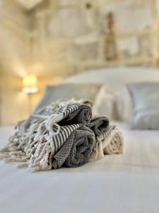 a pile of towels sitting on top of a bed at La Maison Plume, Appart Boutique in Saint-Rémy-de-Provence