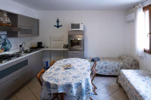 eine Küche mit einem Tisch und eine Küche mit 2 Betten in der Unterkunft {Il Blue di Grado} in Grado