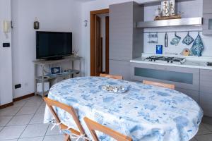 eine Küche mit einem Tisch mit Stühlen und einem Herd in der Unterkunft {Il Blue di Grado} in Grado