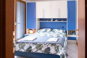 Schlafzimmer mit einem Bett mit blauer Wand in der Unterkunft {Il Blue di Grado} in Grado