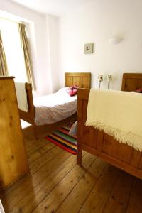 1 dormitorio con 2 camas y suelo de madera en Trawler Cottage traditional cottage with stunning sea view, en Newlyn