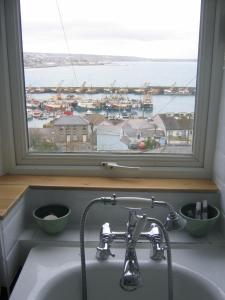 fregadero de cocina con ventana con vistas al puerto en Trawler Cottage traditional cottage with stunning sea view, en Newlyn