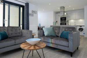 a living room with two couches and a table at 6 Putsborough - Luxury Apartment at Byron Woolacombe, only 4 minute walk to Woolacombe Beach! in Woolacombe