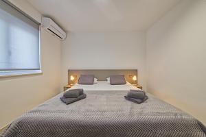a bedroom with a large bed with two pillows at Villa Ankica in Tribunj