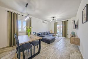 een woonkamer met een tafel en een bank bij Villa Ankica in Tribunj