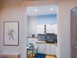 a kitchen with white cabinets and a table in it at A casa di Chiara Salerno in Salerno