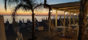 restauracja na plaży ze stołami i krzesłami w obiekcie Scirocco e Maestrale w mieście Petrosino