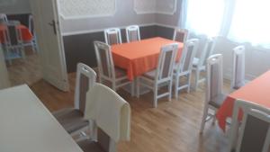 a dining room with an orange table and chairs at Karpatia Vendeghaz 1201 Budapest in Budapest