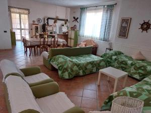 Una sala de estar con sofás y un comedor. en Casa con giardino Giacalone, en Mazara del Vallo