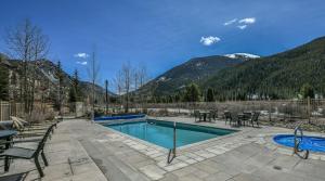 a swimming pool with tables and chairs and mountains at Red Hawk Townhomes 2333 in Keystone
