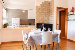 a dining room with a table and white chairs at Garda residence Gardaland in Castelnuovo di Verona