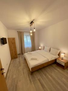 a bedroom with a large bed and two lamps at Cosy&Minimalistic Apartments - Haret Building in Sinaia