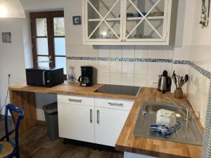 a kitchen with a sink and a microwave at La marine D'opale in Ambleteuse