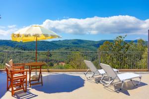 a patio with a table and chairs and an umbrella at Archontiko Aliki in Sgourádes