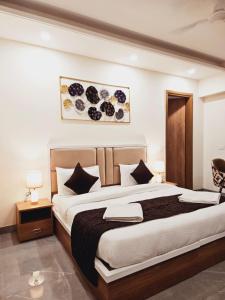 1 dormitorio con 1 cama grande con almohadas blancas y negras en Amahi Inn - Sector 48, en Gurgaon