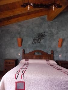 1 dormitorio con 1 cama con colcha blanca en CASAS RURALES LAS ERAS 1 Y 2, en Santa María de Riaza