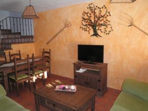 sala de estar con TV, mesa y sillas en CASAS RURALES LAS ERAS 1 Y 2, en Santa María de Riaza