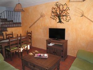 a living room with a television and a table and chairs at Casas Rurales Las Eras I A Y II B in Santa María de Riaza