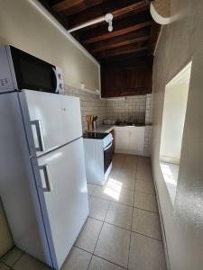 a kitchen with a white refrigerator and a tile floor at Magnifique Cottage à Lescun in Lescun