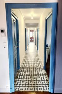 a hallway with blue doors and a white and black tile floor at Magnifique Cottage à Lescun in Lescun