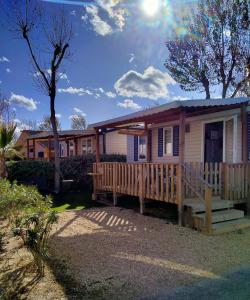 a small house with a porch and a deck at Mobil-home Les Locs Danous in Valras-Plage
