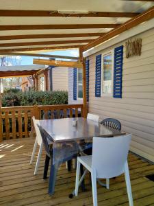 un tavolo e sedie su una terrazza in legno di Mobil-home Les Locs Danous a Valras-Plage